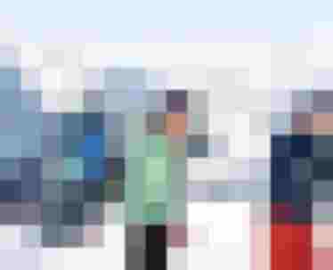 Kinder werfen Schneebälle im Skigebiet mit Eltern im Hintergrund